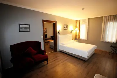 a bedroom with a bed and a couch and a chair at Montania Town Hotel Mudanya in Mudanya