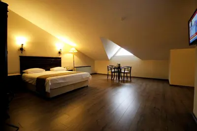 a bedroom with a bed and a table and a television at Montania Town Hotel Mudanya in Mudanya