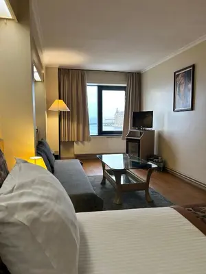 a hotel room with a bed and a couch and a table at Kadıköy Rıhtım Hotel in Istanbul