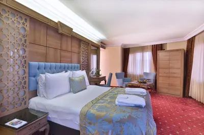 a bedroom with a large bed with a blue headboard at Budo Hotel in Istanbul