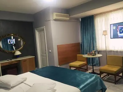 a bedroom with a bed and a table and chairs at Masal Otel in Kocaeli