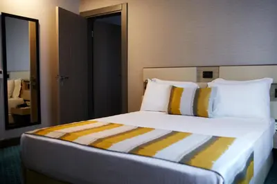 a bedroom with a large bed with yellow and white pillows at Tophane Suites in Istanbul