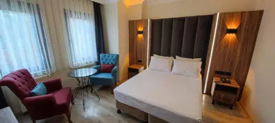 a bedroom with a bed and two chairs and a table at Star Hotel in Istanbul