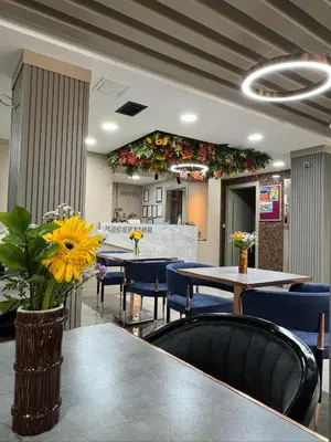 a restaurant with tables and blue chairs and flowers at Best Nobel Hotel in Istanbul