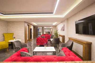 a waiting room with red couches and a flat screen tv at Sim Hotel Istanbul Old City in Istanbul