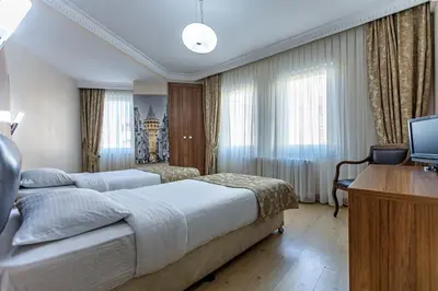 a hotel room with two beds and a desk at Elasophia Hotel in Istanbul