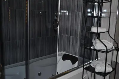 a bathroom with a shower and a tub with towels at Gumus Palace Suites in Istanbul