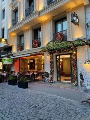 a restaurant with tables and chairs in front of a building at Asur Hotel in Istanbul
