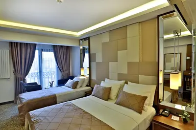 a hotel room with two beds and a mirror at Grand Sagcanlar Hotel in Istanbul