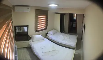 two beds in a small room with a window at Beyoglu Huzur Hotel in Istanbul