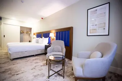 a hotel room with two beds and two chairs at Ramada Plaza By Wyndham Sultanahmet in Istanbul