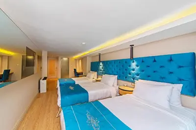two beds in a hotel room with a blue headboard at History Hotel in Istanbul
