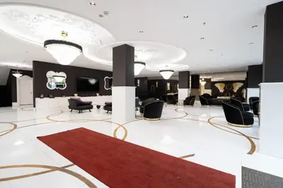 a lobby with black chairs and a red rug at Golden Pars Hotel in Bursa