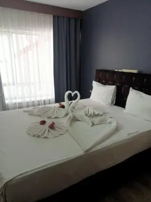 a bed with two swans sitting on top of it at Hotel Cesmeli in Bursa