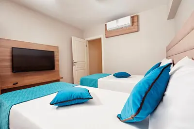 two beds in a room with two blue pillows at Bursa Suites Apart Otel in Bursa