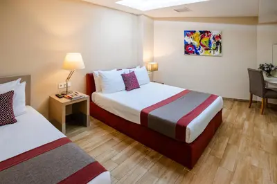 a hotel room with two beds and a table at Cheya Sisli BNB Medical & Business City Center Tesvikiye Suites and Apartments in Istanbul