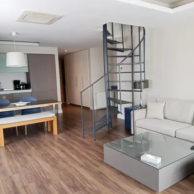 a living room with a couch and a spiral staircase at Cheya Deluxe Residence Nisantasi Istanbul City Center in Istanbul