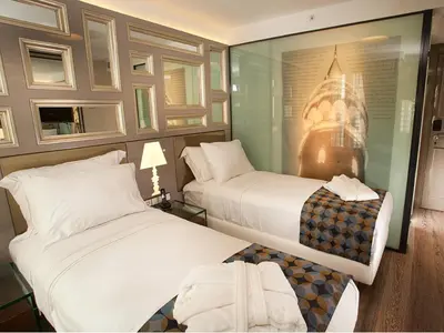 a hotel room with two beds and a glass wall at Hotel La Villa in Istanbul