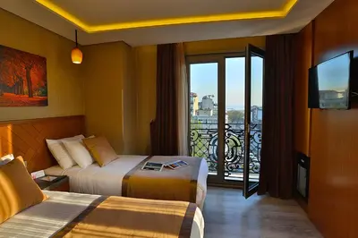 a hotel room with two beds and a balcony at Corner Hotel Laleli in Istanbul
