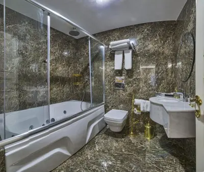 a bathroom with a tub and a toilet and a sink at Glorious Hotel in Istanbul