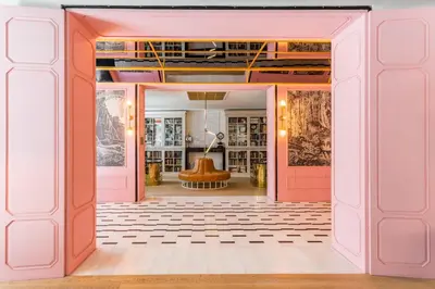 a hallway with pink doors and a room with a chair at The Wings Hotels Collection in Istanbul