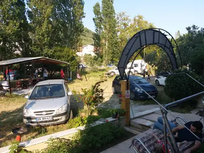a car parked in a parking lot next to a tent at Sağlık Apart Pansiyon in Erdek