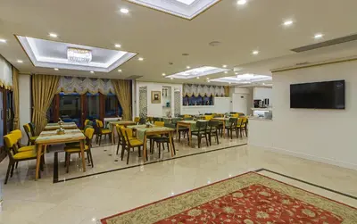 a restaurant with tables and chairs and a flat screen tv at Grand Naki Hotel in Istanbul