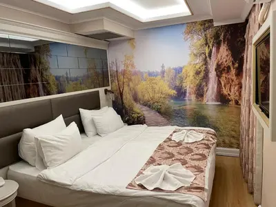 a bedroom with a bed with a painting on the wall at Grand Naki Hotel in Istanbul