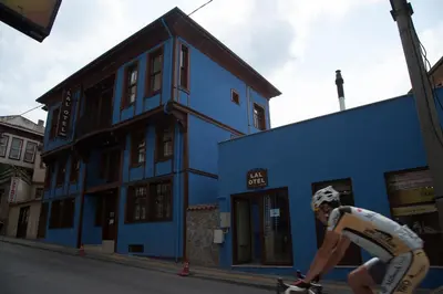 a man riding a skateboard in front of a blue building at Lal Hotel Bursa in Bursa