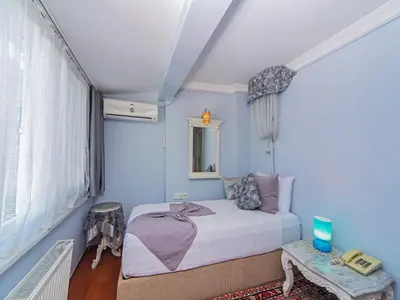 a bedroom with blue walls and a bed and a table at Modern Sultan Hotel in Istanbul