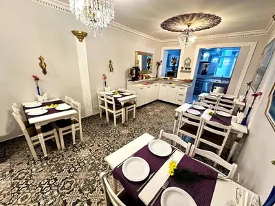 a dining room with tables and chairs and a kitchen at Modern Sultan Hotel in Istanbul