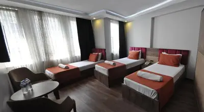 a hotel room with three beds and a table at Waha Hotel in Bursa