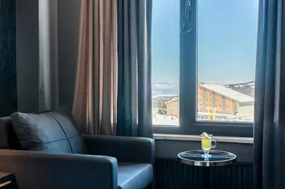 a room with a chair and a table and a window at Trendlife Hotels Uludağ ALL INCLUSIVE in Uludag