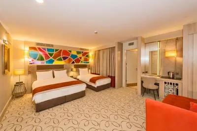 a hotel room with two beds and a desk at MARE PARK Hotel & SPA in Istanbul