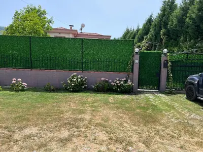 a fence with flowers in front of a house at Villa Onuk in Sapanca