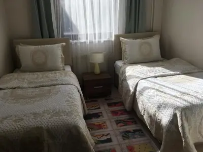 two beds in a small room with a window at Villa Onuk in Sapanca