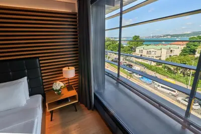 a bedroom with a large window with a view of a train at Metropolitan Hotels Bosphorus - Special Category in Istanbul