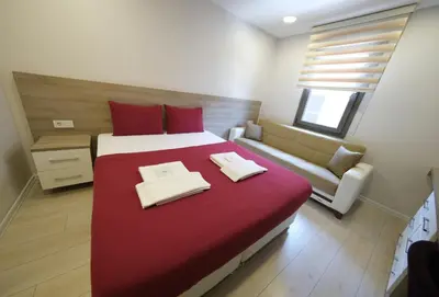 a bedroom with a red bed and a couch at Uçar Royal Hotel ve Konferans Salonu in Sile