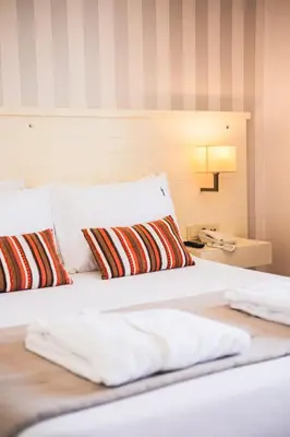 a bedroom with a bed with two pillows and a phone at Tiara Buyukada in Buyukada