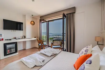 a bedroom with a bed with a fireplace and a balcony at Tiara Buyukada in Buyukada