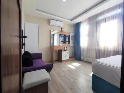 a bedroom with a bed and a couch and a window at Grafen House in Istanbul