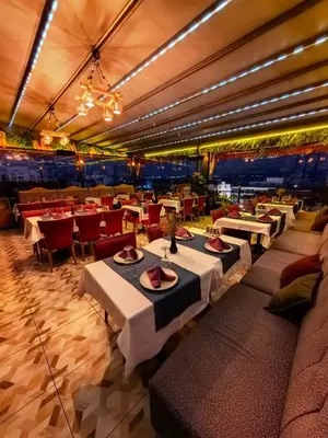 a restaurant with white tables and red chairs at Apple Tree Hotel in Istanbul