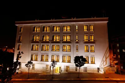 a large white building with lit windows at night at Zin D Home Otel Cekmeköy in Istanbul