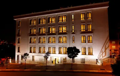 a large white building with lit windows at night at Zin D Home Otel Cekmeköy in Istanbul