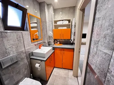 a bathroom with orange cabinets and a sink and a mirror at Zin D Home Otel Cekmeköy in Istanbul