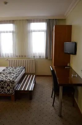 a hotel room with a bed and a table and a desk at Atlas Otel in Bursa