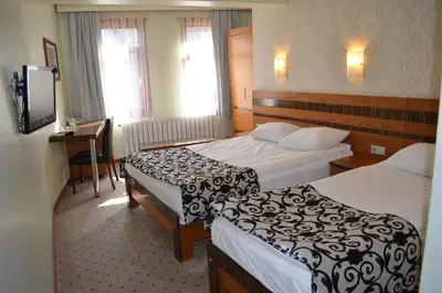 a hotel room with two beds and a desk at Atlas Otel in Bursa