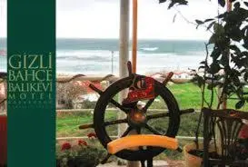 a bike wheel sitting in front of a window at Gizlibahce Hotel in Karaburun