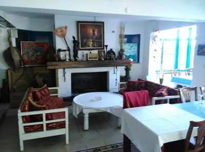 a living room with a fireplace and a table at Gizlibahce Hotel in Karaburun