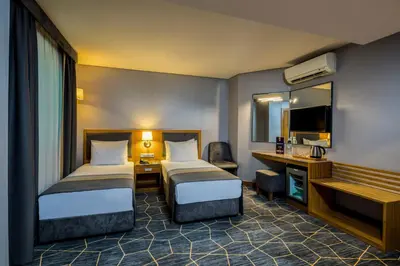 a hotel room with two beds and a desk at Hotel Venera Istanbul Old City in Istanbul
